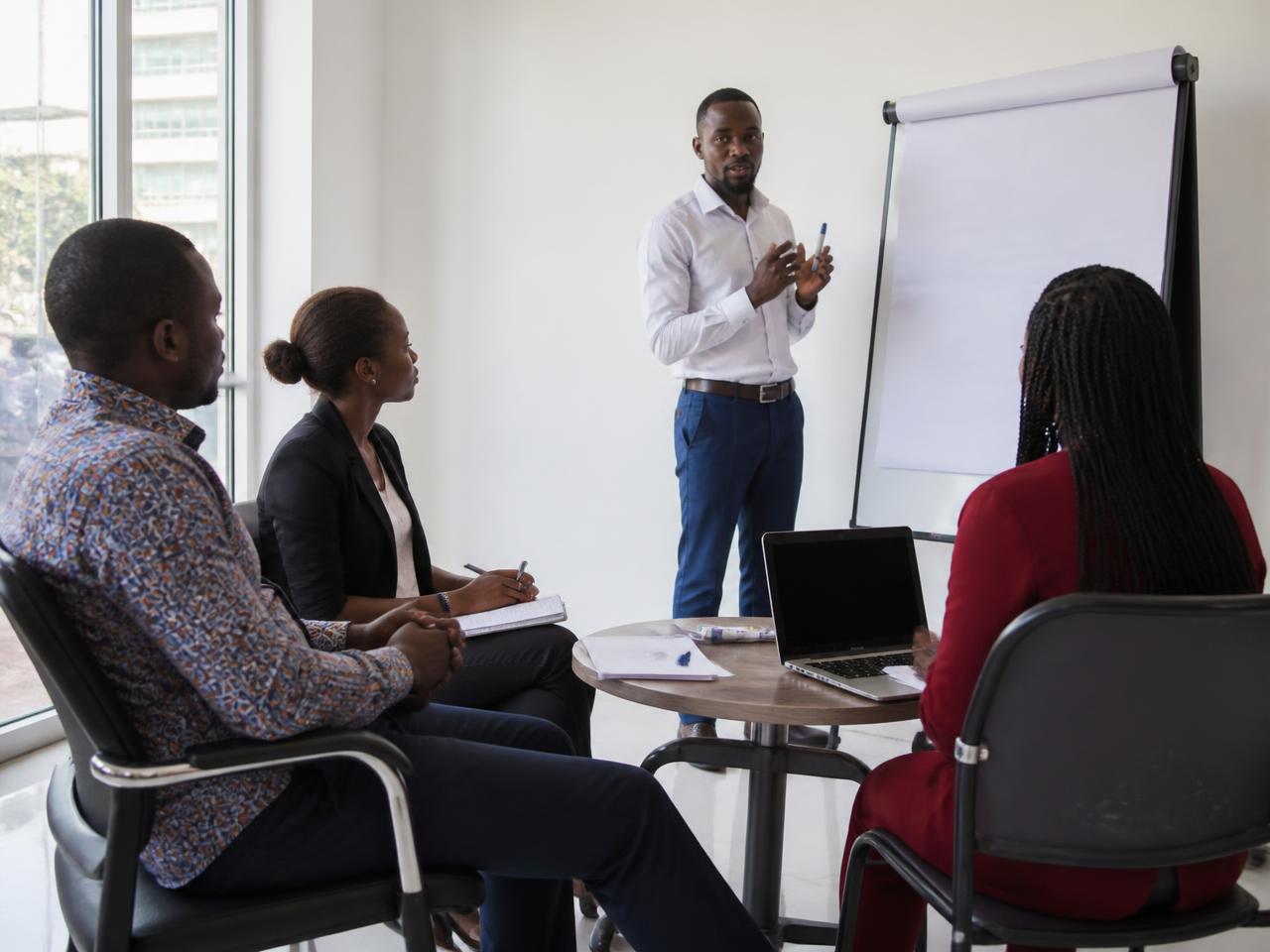 A facilitator leading an accelerator session with participants taking notes